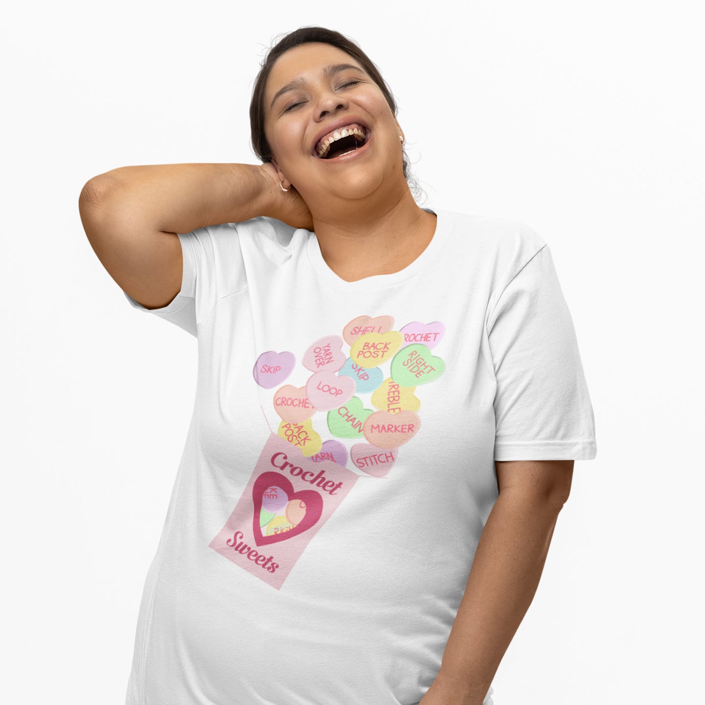 Modeled product image of Moxie•Pop's unisex graphic tee with a 'Crochet Sweets' valentine's conversation hearts with crochet terms design in white