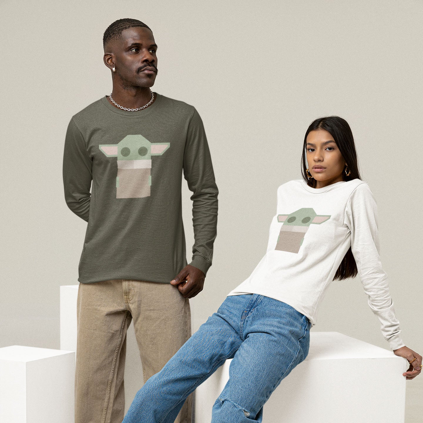 Modeled product image of Moxie•Pop's men's long sleeve graphic tee with a stylized geometric Grogu design in military green and white. 