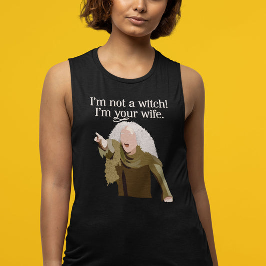 Modeled product image of Moxie•Pop's women's muscle tank with a illustration Valerie from The Princess Bride with the phrase 'I'm Not a Witch! I'm you wife." in black