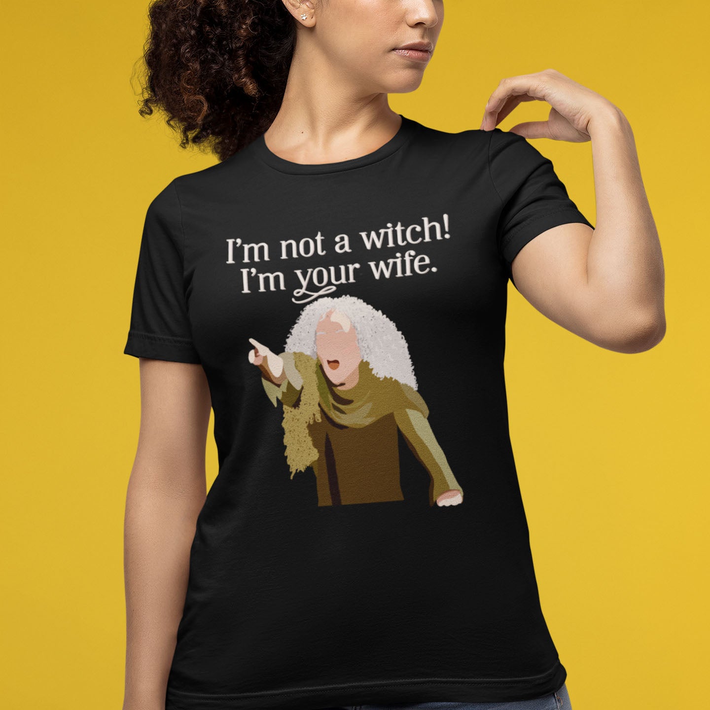 Modeled product image of Moxie•Pop's unisex graphic tee with a illustration Valerie from The Princess Bride with the phrase 'I'm Not a Witch! I'm you wife." in black heather