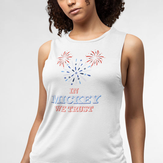 Modeled product image of Moxie•Pop's women's muscle tank with hand-drawn fireworks in the shape of Mickey Mouse silhouette with the phrase "In Mickey We Trust"  in white