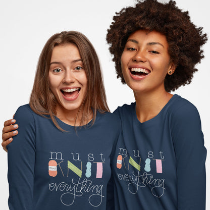 Modeled product image of Moxie•Pop's men's long sleeve graphic tee with hand lettered 'Must Knit Everything' with the word knit created from illustrations of yarn, needles, and knitting in navy