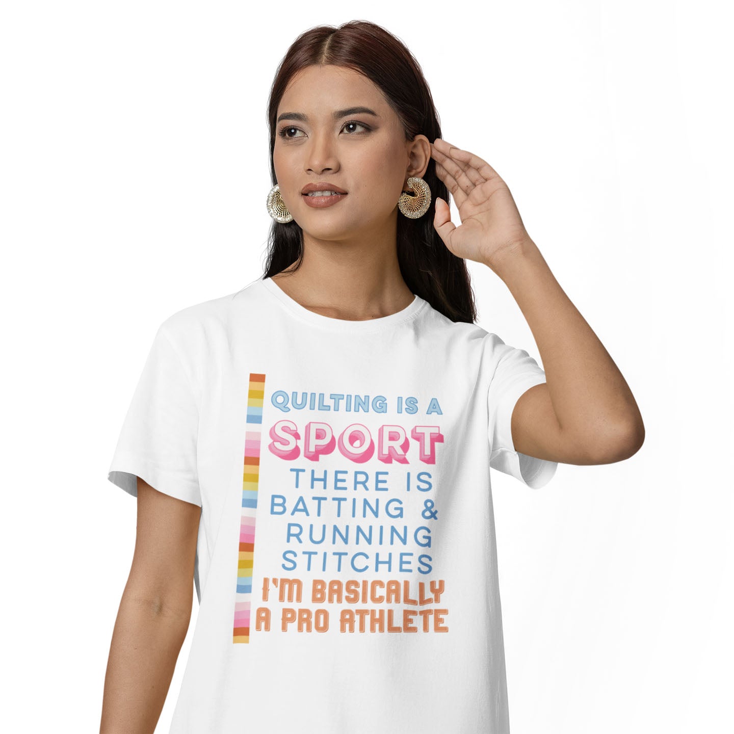 Moxie•Pop's unisex graphic tee with "Quilting is a sport There is batting & running stitches. I'm basically a pro athlete." design in blue, pink, and orange in white modeled by a woman with long hair and a white backdrop