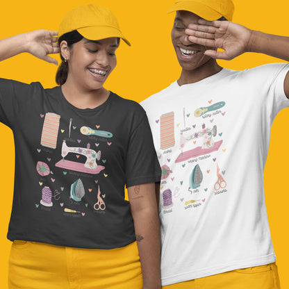 Modeled product image of Moxie•Pop's unisex graphic tee with a hand-drawn design of a series of sewing tools with their names below design in dark grey heather and white. Models are wearing yellow pants and hats with a yellow backdrop. 