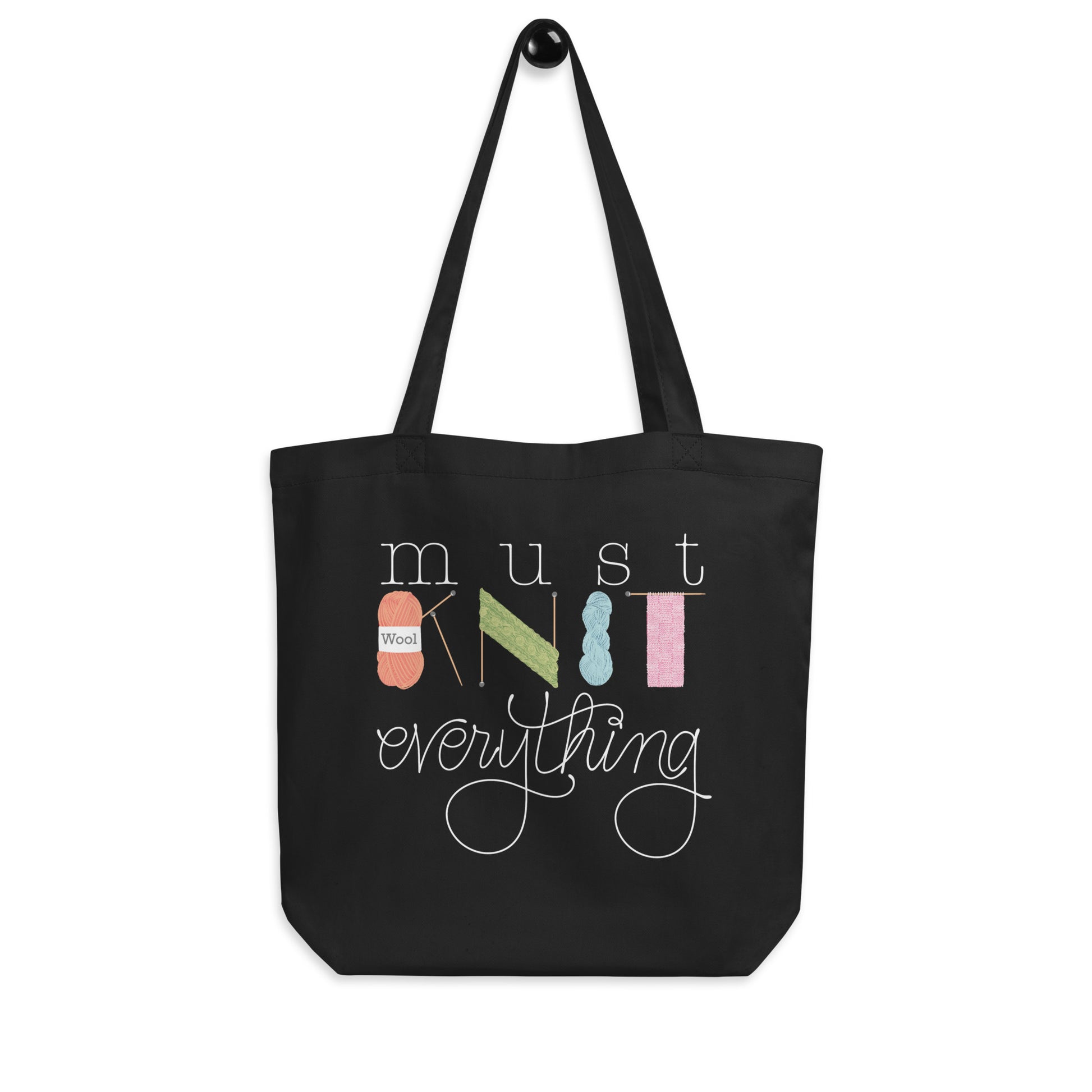 hanging product image of Moxie•Pop's eco tote bag with hand lettered 'Must Knit Everything' with the word knit created from illustrations of yarn, needles, and knitting in black