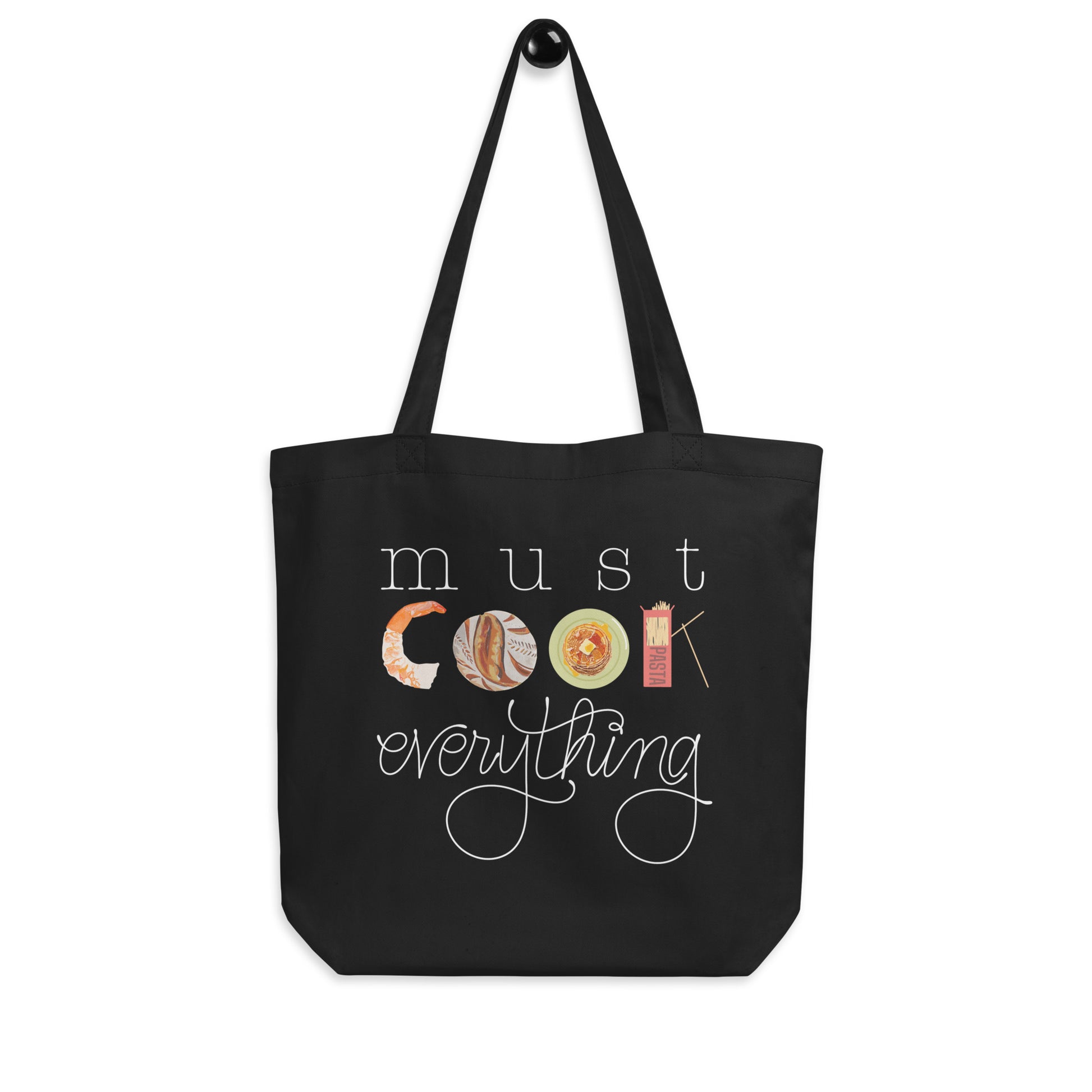 Hanging product image of Moxie•Pop's eco tote bag with hand lettered 'must cook everything' with the word cook created from hand drawn food items in black