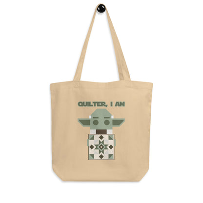 Hanging product image of Moxie•Pop's eco tote bag with a geometric Yoda holding a quilt with the phrase "Quilter, I am" design in oyster