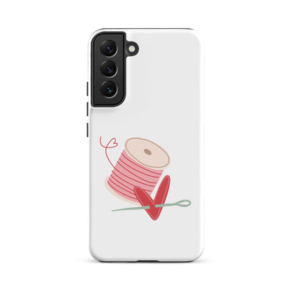 Product image of Moxie•Pop's tough case for Samsung® with a hand-drawn spool of pink thread and a heart pierced by a needle on a Galaxy S22 Plus