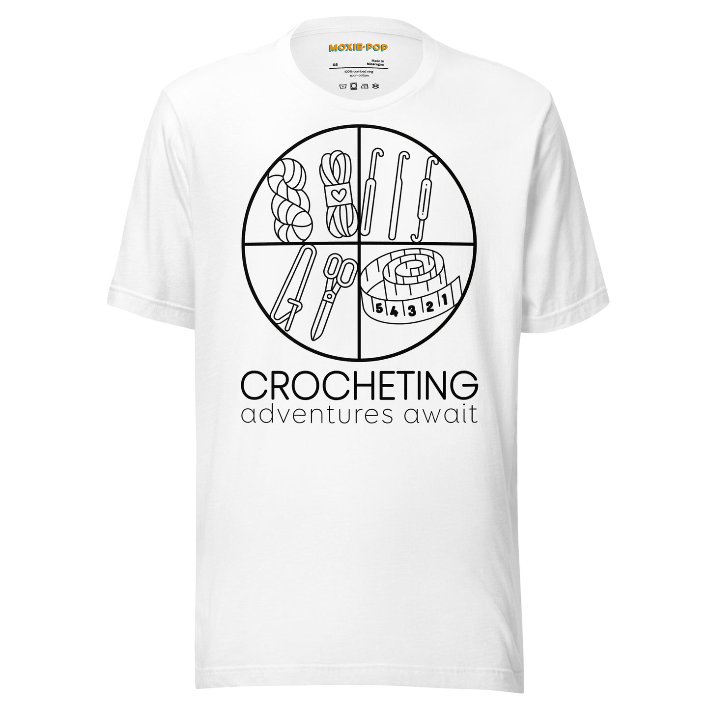 Ghost product image of Moxie•Pop's unisex graphic tee with "CROCHETING adventures await" below a circle filled with crocheting implements icons design in white