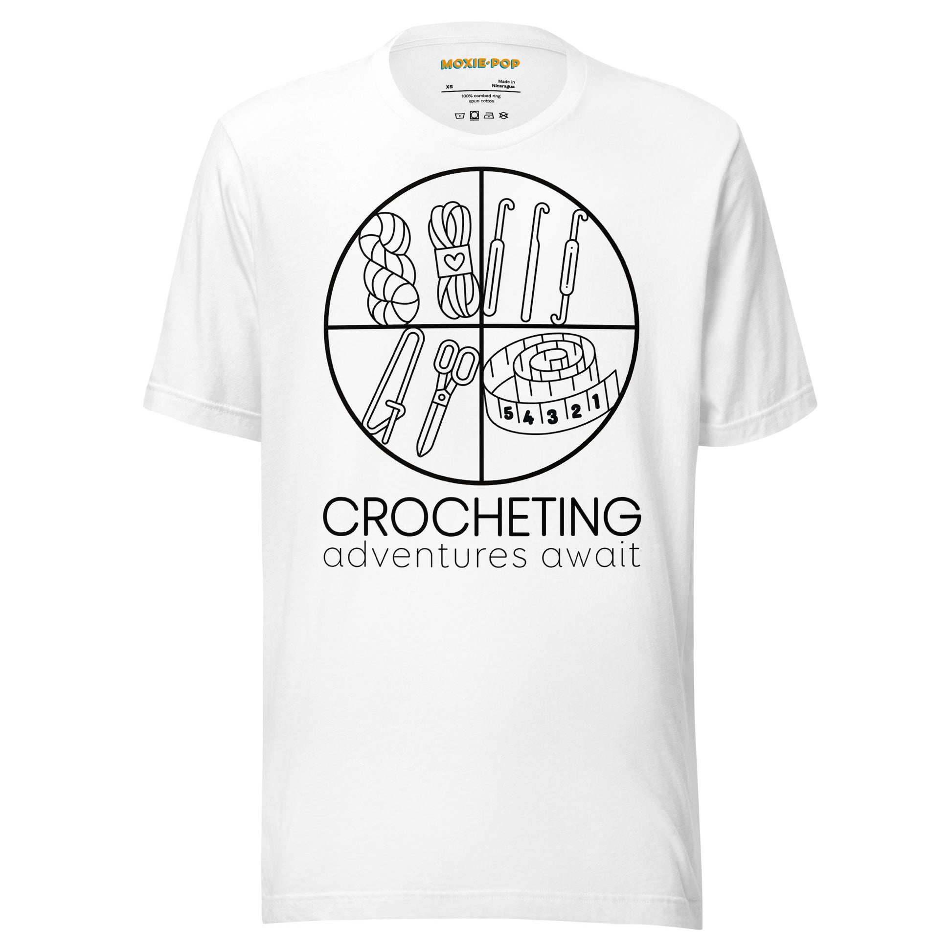 Ghost product image of Moxie•Pop's unisex graphic tee with "CROCHETING adventures await" below a circle filled with crocheting implements icons design in white