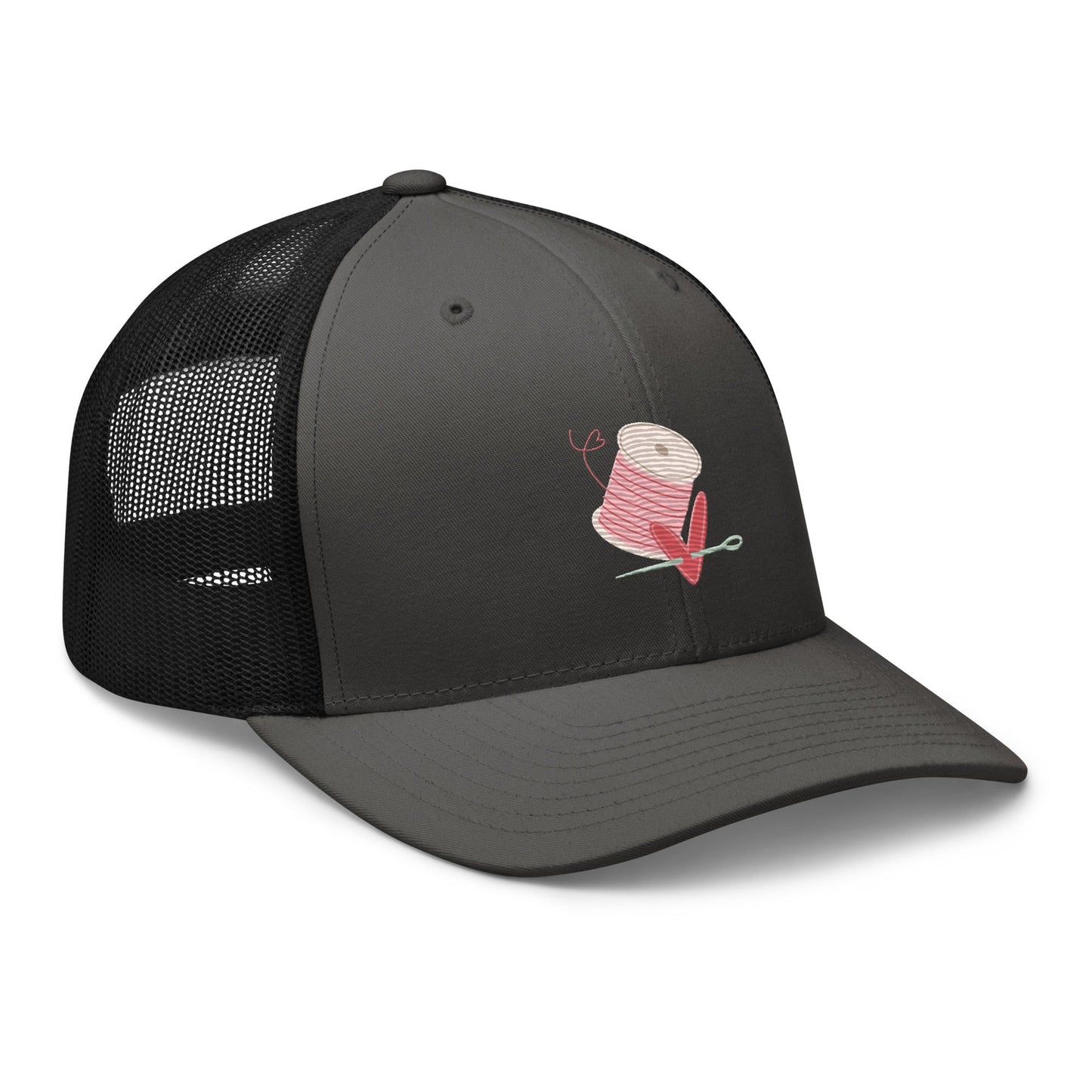 Moxie•Pop's retro trucker hat product image in charcoal with black mesh embroidered with pink spool of thread with a heart being pierced by a needle.