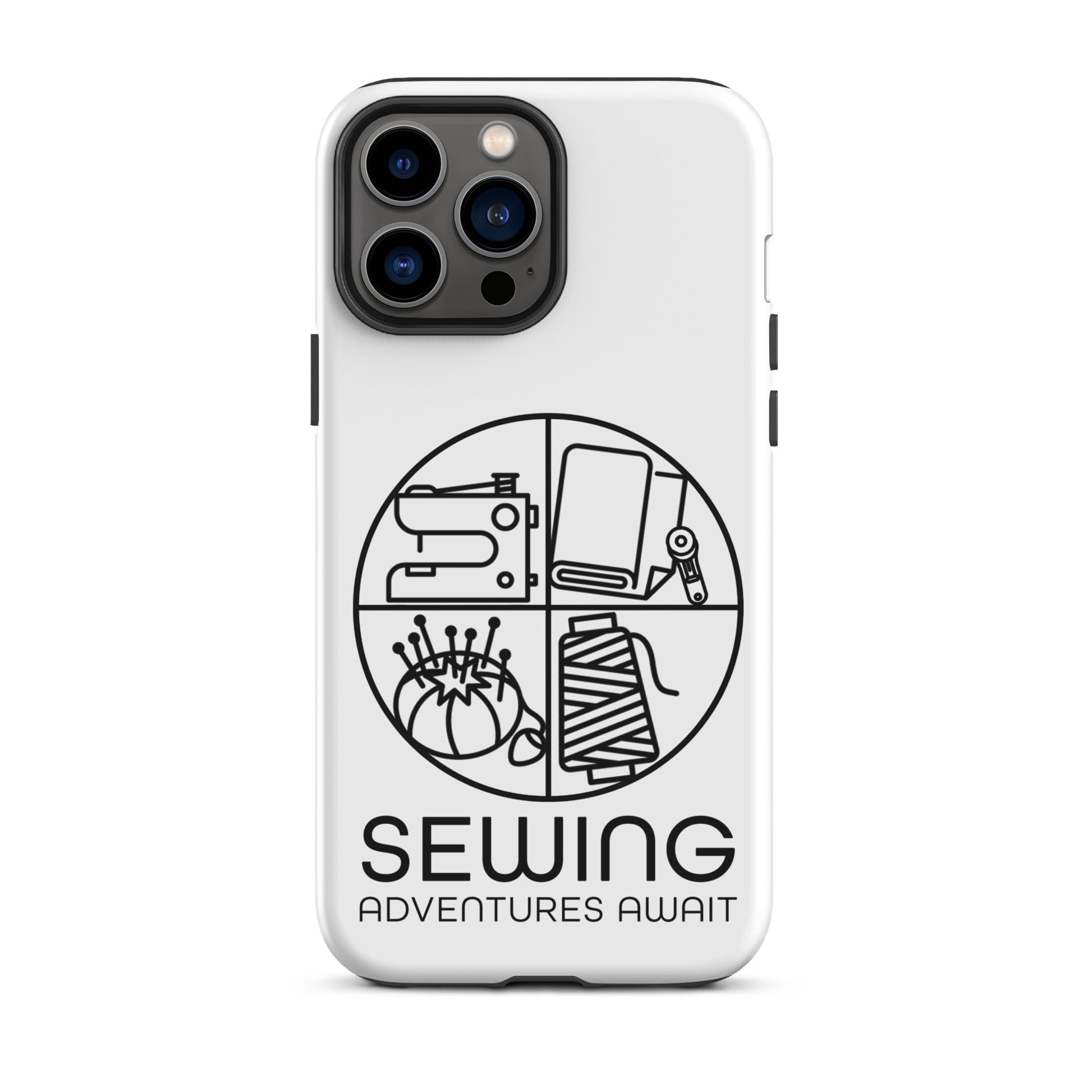 Moxie•Pop's tough case on a iPhone® in white with a black image of a circle in four quadrants each with a sewing tool icon above 'Sewing Adventures Await'. 